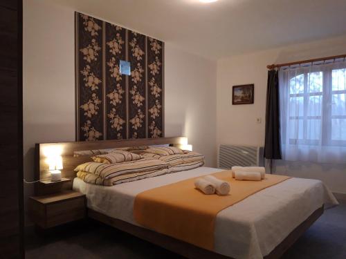 ティサフュレドにあるEszter Vendégházのベッドルーム1室(ベッド1台、タオル2枚付)