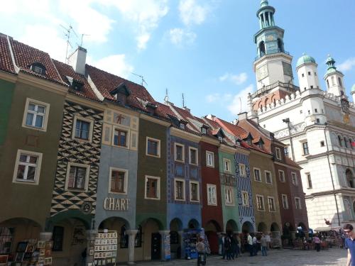 un grupo de edificios frente a un edificio con una torre de reloj en Nest Nocleg Poznań, en Poznan