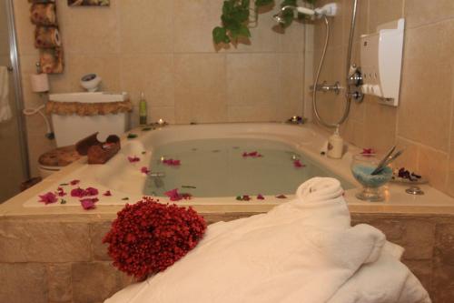 a bathroom with a bath tub filled with flowers at Rosh Pinat Noy in Rosh Pinna
