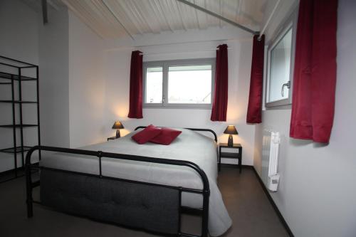 a bedroom with a bed with red curtains and a window at Résidence Beauvoir le Mont-Saint-Michel (9 gîtes de 2 à 5 personnes) in Beauvoir