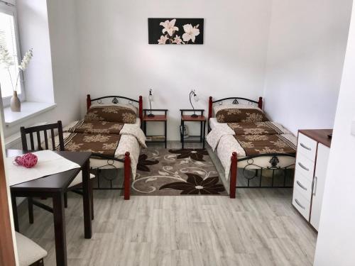 a room with two beds and a table and a table sidx sidx sidx at Apartmány Dagmar in Mariánské Lázně