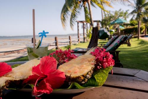 a sandwich on a plate on a table near the beach at Hotel Porto do Zimbo in Morro de São Paulo