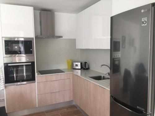 a kitchen with a stainless steel refrigerator and a sink at Esmeralda Apartment in Albir