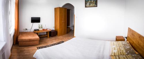 a bedroom with a bed and a chair and a desk at Penzión Marco Polo in Vrútky