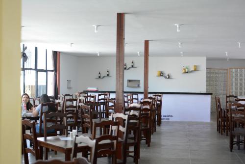 una sala da pranzo con tavoli, sedie e una lavagna bianca di Hotel Villa Real a Sobral