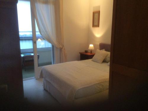 un dormitorio con una cama y una ventana en Pietralba Saint Joseph, en Ajaccio