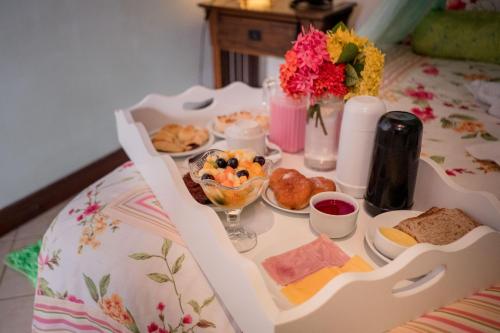 a table with a tray of breakfast food on it at Hotel Porto do Zimbo in Morro de São Paulo