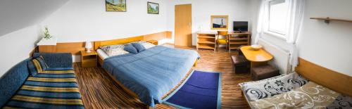 a bedroom with a blue bed and a living room at Penzión Marco Polo in Vrútky
