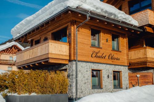 a large wooden building with snow on it at Chalet Olivia in Seefeld in Tirol