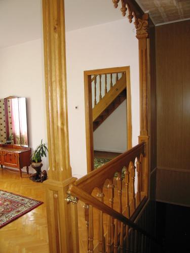a hallway with a wooden staircase in a house at Hostynna Sadyba in Lishnya