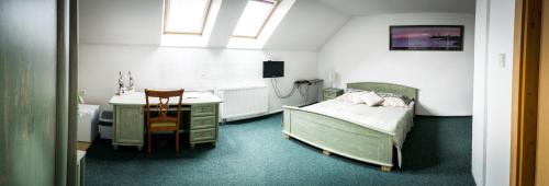a bedroom with a bed and a sink and a desk at Penzión Marco Polo in Vrútky