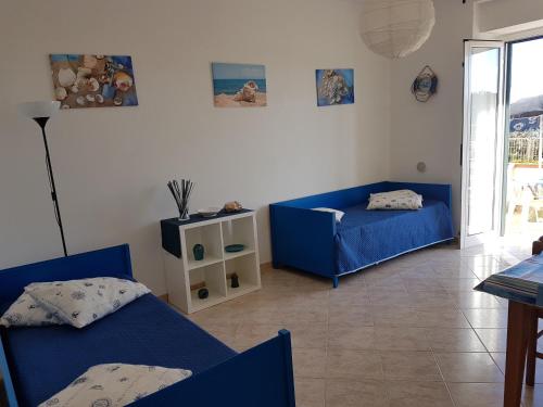 a living room with two beds and a table at Punta Grande - Scala dei Turchi in Realmonte