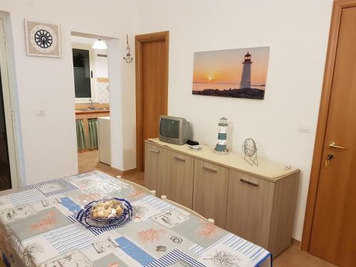 a room with a table and a television and a lighthouse at Punta Grande - Scala dei Turchi in Realmonte