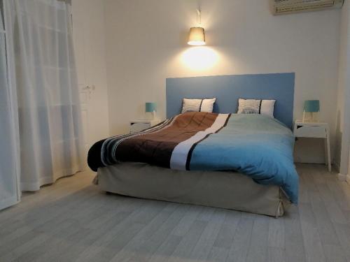 een slaapkamer met een groot bed met een blauw hoofdeinde bij Le Gîte du Cheval Blanc in Fraize