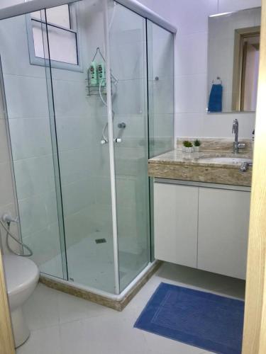 a bathroom with a shower and a toilet and a sink at Villa Verona in Praia do Forte