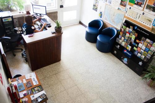 a woman is sitting at a counter in a store at Hostel Hospedarte Chapultepec in Guadalajara