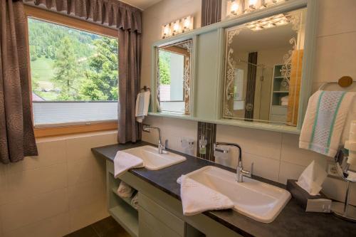 baño con 2 lavabos y ventana en Gästehaus Geir en Obernberg am Brenner