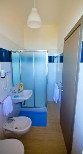 a blue bathroom with a sink and a shower at Hotel Olympia in Senigallia