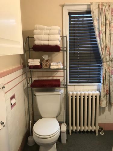 a bathroom with a toilet and towels and a radiator at Mill Stone - Mt Penn Lodging in Mount Penn