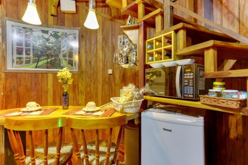 uma cozinha com paredes de madeira e um balcão com duas mesas em Chalé Temático em Pipa de Vinho - Parada da Pipa Chalés em Canela