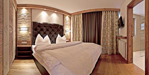 a bedroom with a large bed with a wooden headboard at Alpenchalet Brücke in Mayrhofen