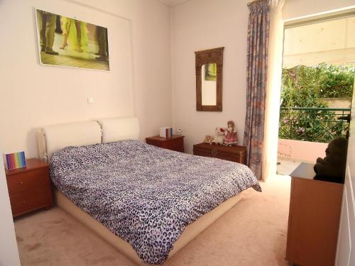 a bedroom with a bed and a window and a mirror at Theo and Kaiti in Athens