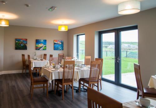 a dining room with tables and chairs and windows at Sheedy's Doolin in Doolin