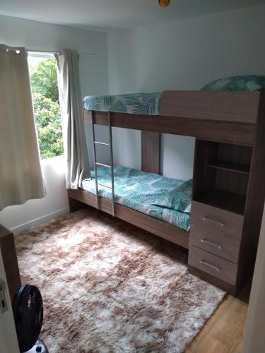 a bedroom with two bunk beds and a window at Minha casa é sua casa in Curitiba