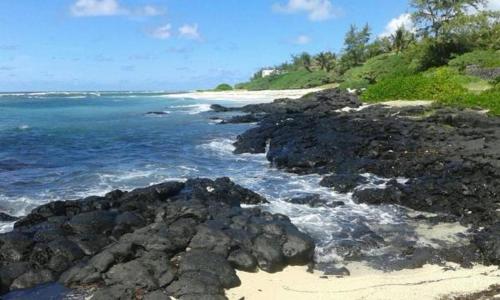 a beach with some rocks and the ocean at Villa Cococherie in Poste Lafayette