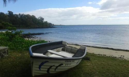 a boat sitting on the shore of a beach at Villa Cococherie in Poste Lafayette