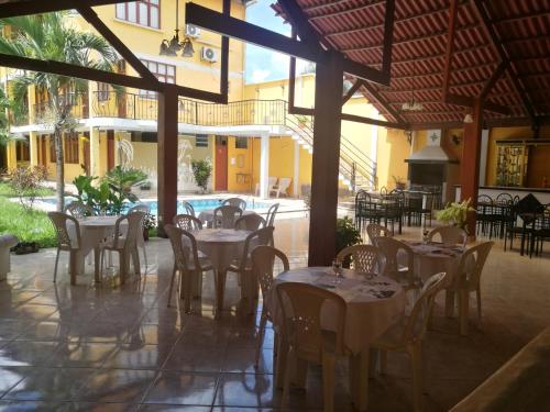 a restaurant with tables and chairs and a pool at Dorado Hotel in Cobija