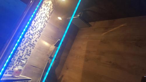a bathroom with a blue light on the wall at modern Hoteliving Gießen in Gießen