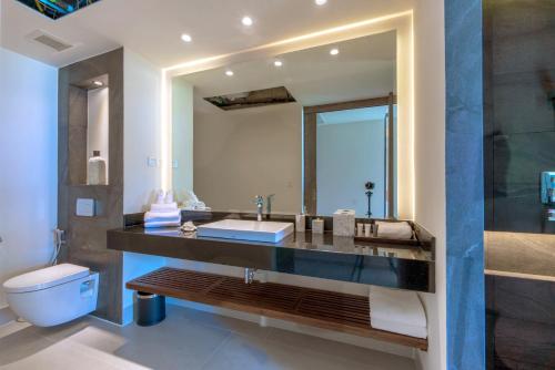 ein Badezimmer mit einem Waschbecken, einem WC und einem Spiegel in der Unterkunft Patong Heights in Patong Beach
