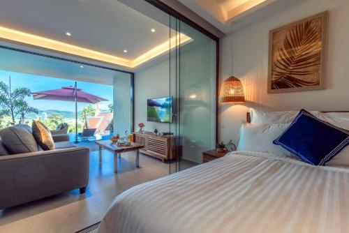 um quarto com uma cama grande e uma sala de estar em Patong Heights em Praia de Patong