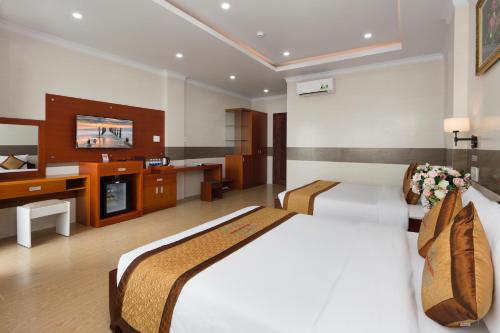a hotel room with two beds and a television at Phuc Ngoc Hotel in Ap Rạch Soi