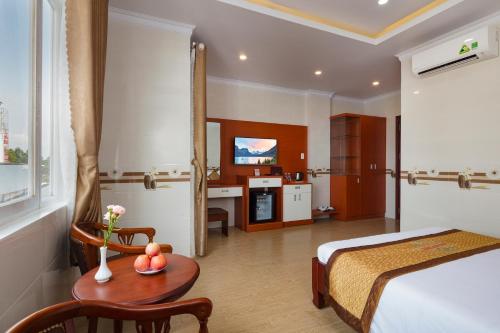 a hotel room with a bed and a table with fruit on it at Phuc Ngoc Hotel in Ap Rạch Soi