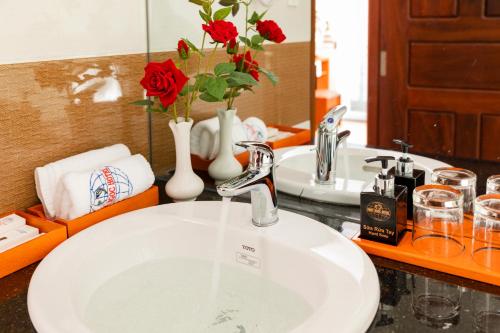 a bathroom sink with two sinks with red roses at Phuc Ngoc Hotel in Ap Rạch Soi
