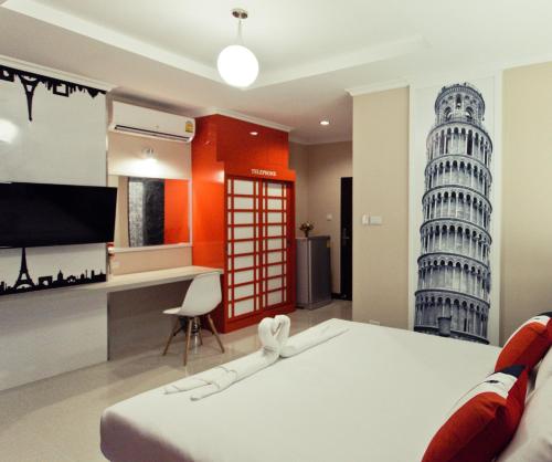 a bedroom with a bed and a desk and a tower at The Proud Hotel in Ubon Ratchathani