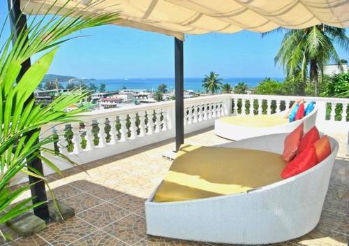 a white chair sitting on a balcony with an umbrella at Villa Versace Residence in Patong Beach