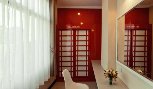 two red telephone booths in a room with a vase of flowers at The Proud Hotel in Ubon Ratchathani