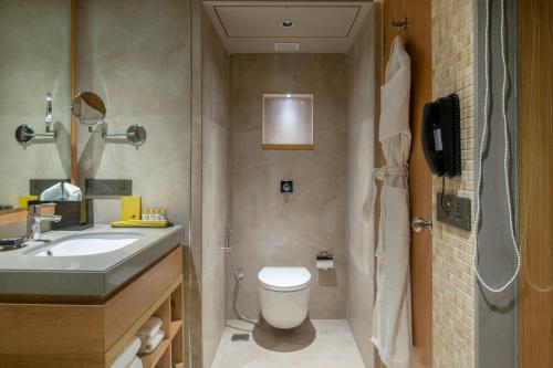 a bathroom with a toilet and a sink and a phone at Modi Yoga Retreat Rishikesh in Rishīkesh