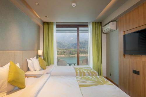a hotel room with a bed and a large window at Modi Yoga Retreat Rishikesh in Rishīkesh