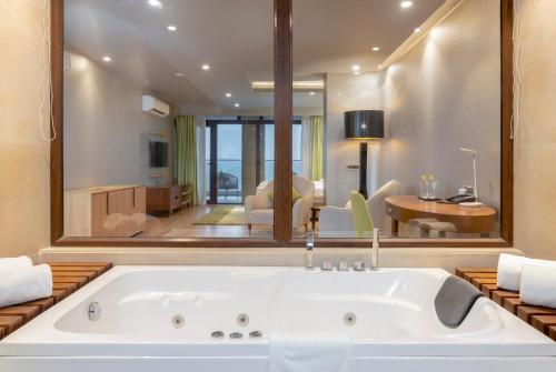 a bath tub in a room with a large mirror at Modi Yoga Retreat Rishikesh in Rishīkesh