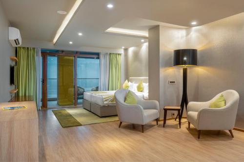 a hotel room with a bed and two chairs at Modi Yoga Retreat Rishikesh in Rishīkesh