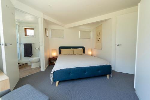 a bedroom with a large bed and a bathroom at Wedgetail in Dinner Plain