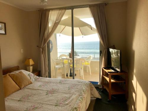 a bedroom with a bed and a view of the ocean at Oceanic Playa La Serena in La Serena