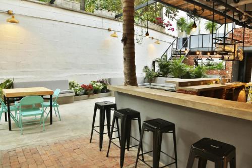 a patio with stools and a bar with plants at Santuario Getsemani Hostel in Cartagena de Indias