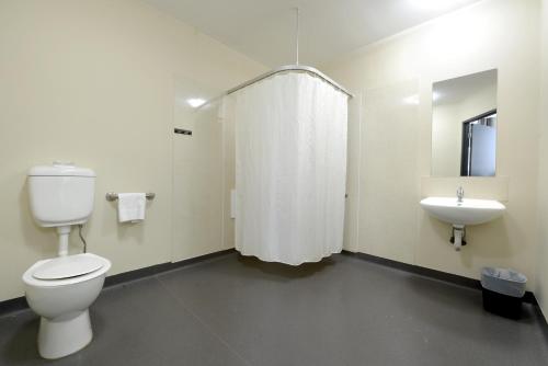 a white toilet sitting next to a white sink at ibis Budget - Melbourne CBD in Melbourne