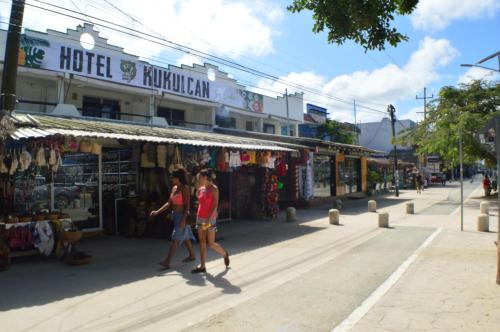two people walking down a street in front of a store at Kukulcan by Emotion in Tulum