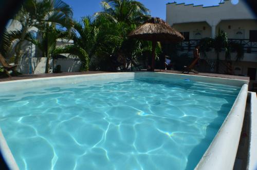 a large blue swimming pool with an umbrella at Kukulcan by Emotion in Tulum